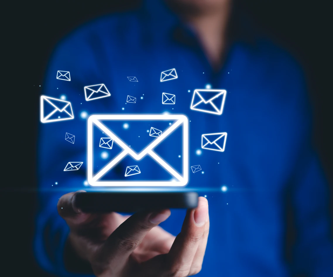 Hand holding phone with email symbols